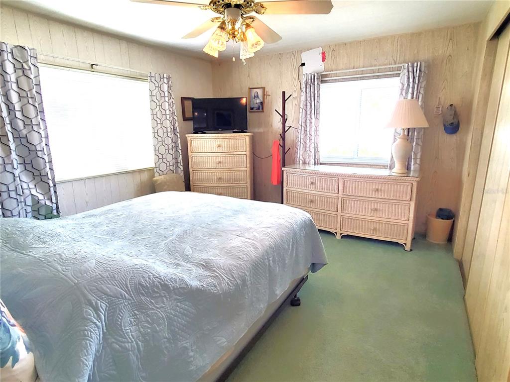 176 West Manatee Loop Punta Gorda, FL 33950 - Photo 21 of 63 a bedroom with a bed and a flat tv screen on dresser