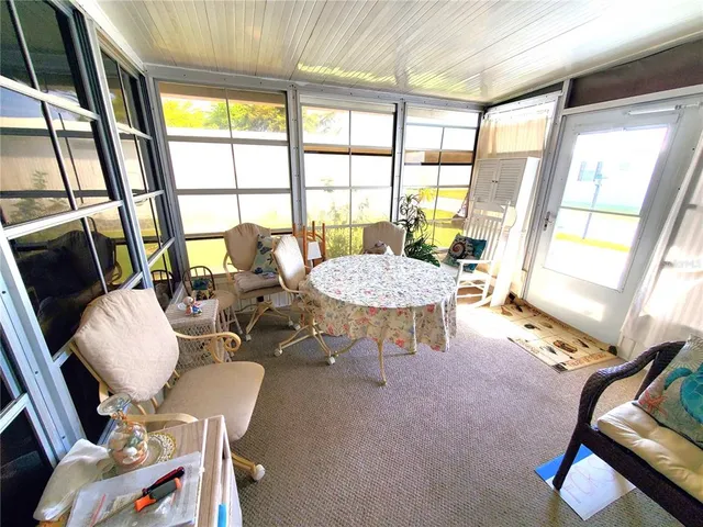 a vase of flowers sitting on a floor in front of a window