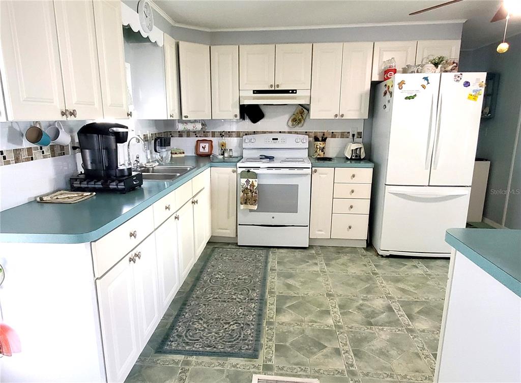 176 West Manatee Loop Punta Gorda, FL 33950 - Photo 10 of 63 a kitchen with a white cabinets and white appliances