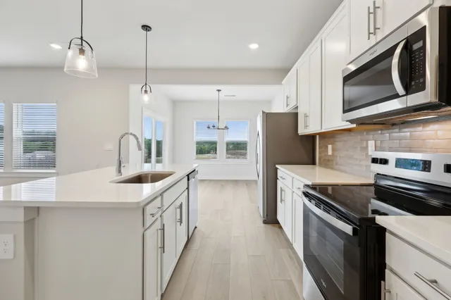 a kitchen with stainless steel appliances granite countertop a sink a stove oven and refrigerator