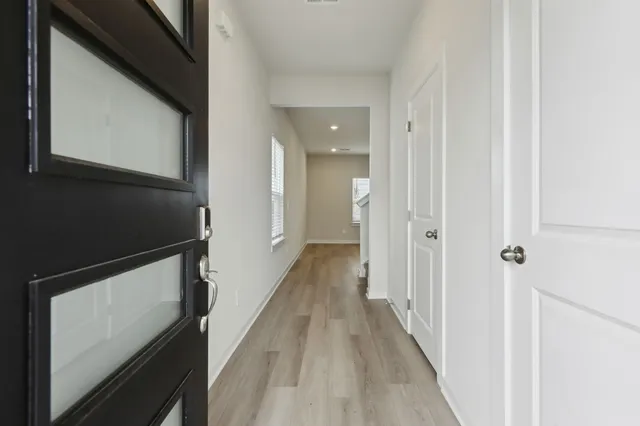 a view of a hallway with wooden floor and staircase