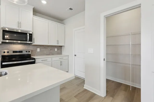 a kitchen with cabinets and steel appliances