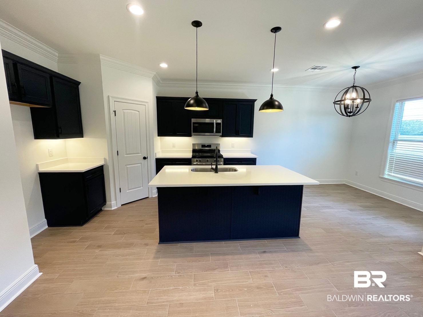 1396 Fenton Circle Foley, AL 36535 - Photo 2 of 14 Kitchen with an island with sink, appliances with stainless steel finishes, a notable chandelier, decorative light fixtures, and sink