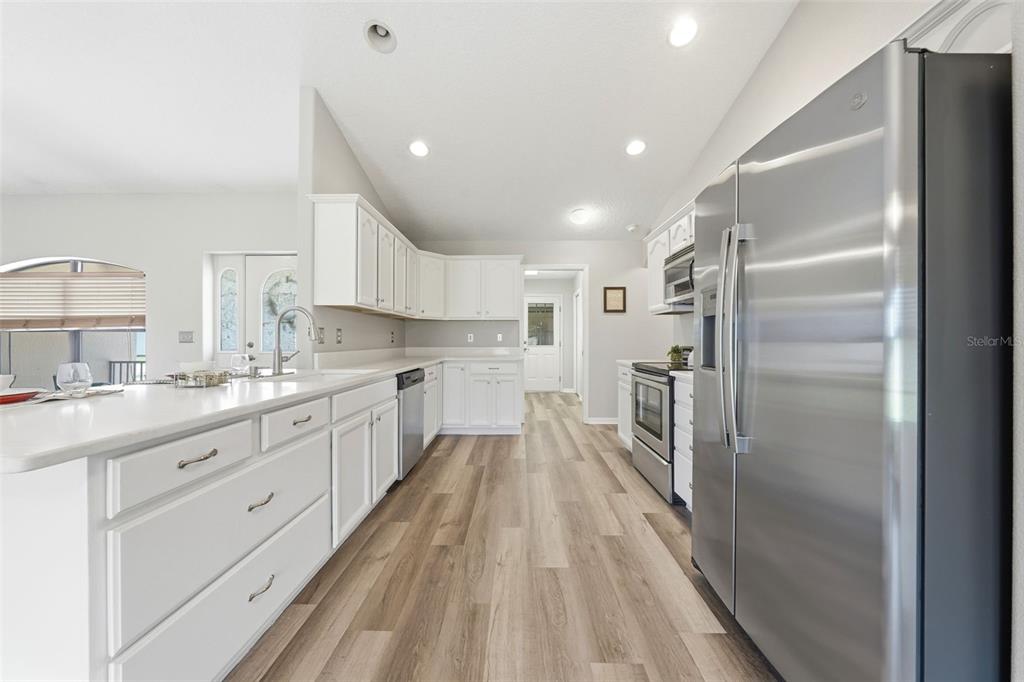 14433 Lake Yale Road Umatilla, FL 32784 - Photo 10 of 38 a large kitchen with a center island wooden floor and stainless steel appliances