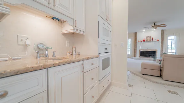 a kitchen with stainless steel appliances kitchen island granite countertop a table chairs sink and cabinets