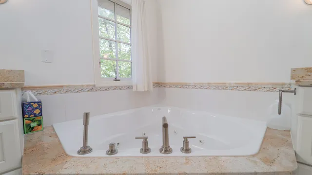 a spacious bathroom with a granite countertop sink a mirror and a shower