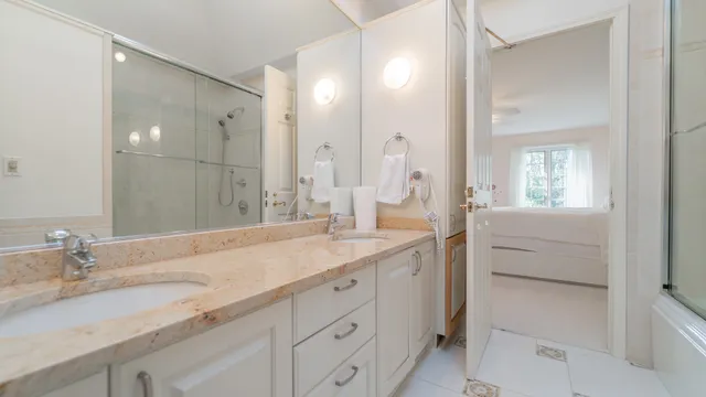 a bathroom with a shower sink and mirror