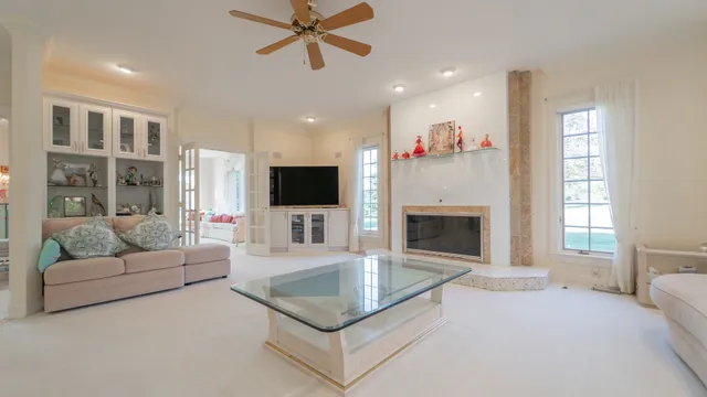 a living room with furniture ceiling fan and a large window