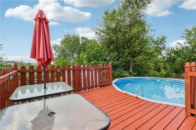 a view of a roof deck with table & chairs wooden floor and fence
