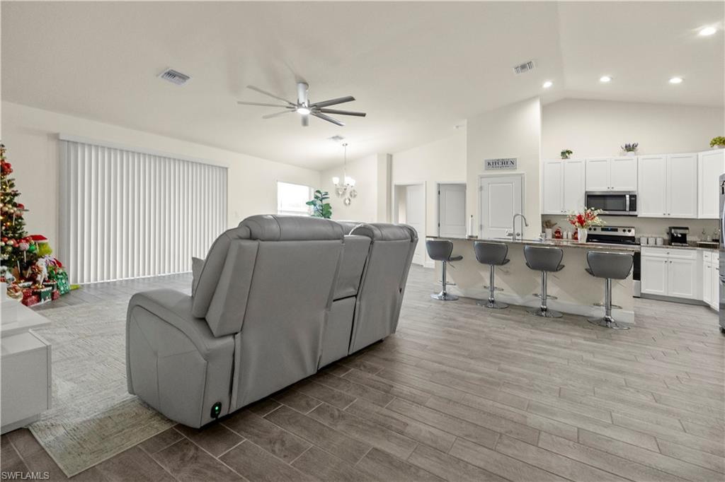 2512 20th Street Southwest Lehigh Acres, FL 33976 - Photo 17 of 48 a living room with furniture and a chandelier