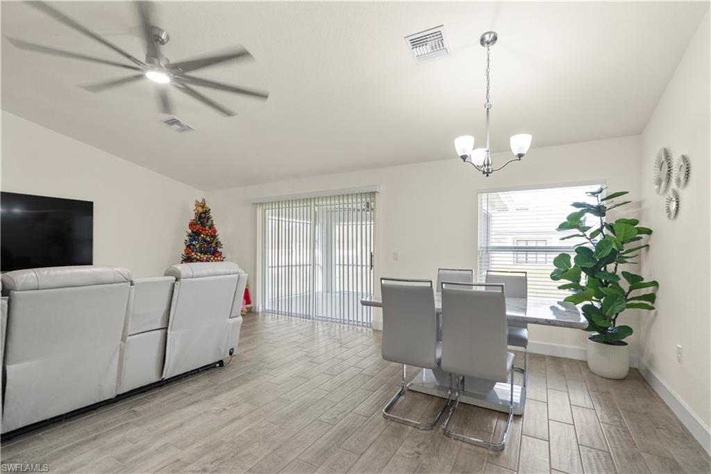 2512 20th Street Southwest Lehigh Acres, FL 33976 - Photo 19 of 48 a living room with furniture and a chandelier