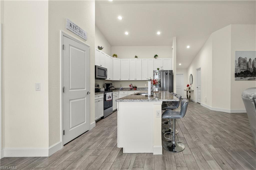 2512 20th Street Southwest Lehigh Acres, FL 33976 - Photo 21 of 48 a kitchen with white cabinets and refrigerator