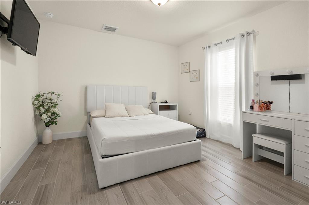 2512 20th Street Southwest Lehigh Acres, FL 33976 - Photo 26 of 48 a bedroom with a bed and a flat screen tv