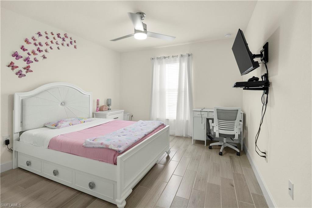 2512 20th Street Southwest Lehigh Acres, FL 33976 - Photo 27 of 48 a bedroom with a bed and a chandelier