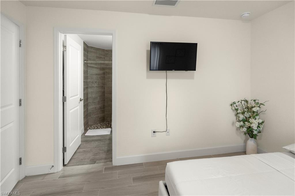 2512 20th Street Southwest Lehigh Acres, FL 33976 - Photo 31 of 48 a bedroom with a bed and a flat screen tv