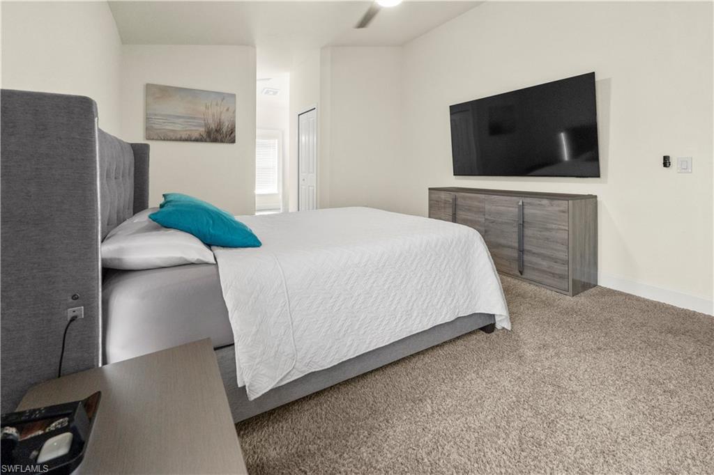 2512 20th Street Southwest Lehigh Acres, FL 33976 - Photo 33 of 48 a bedroom with a bed and a flat screen tv