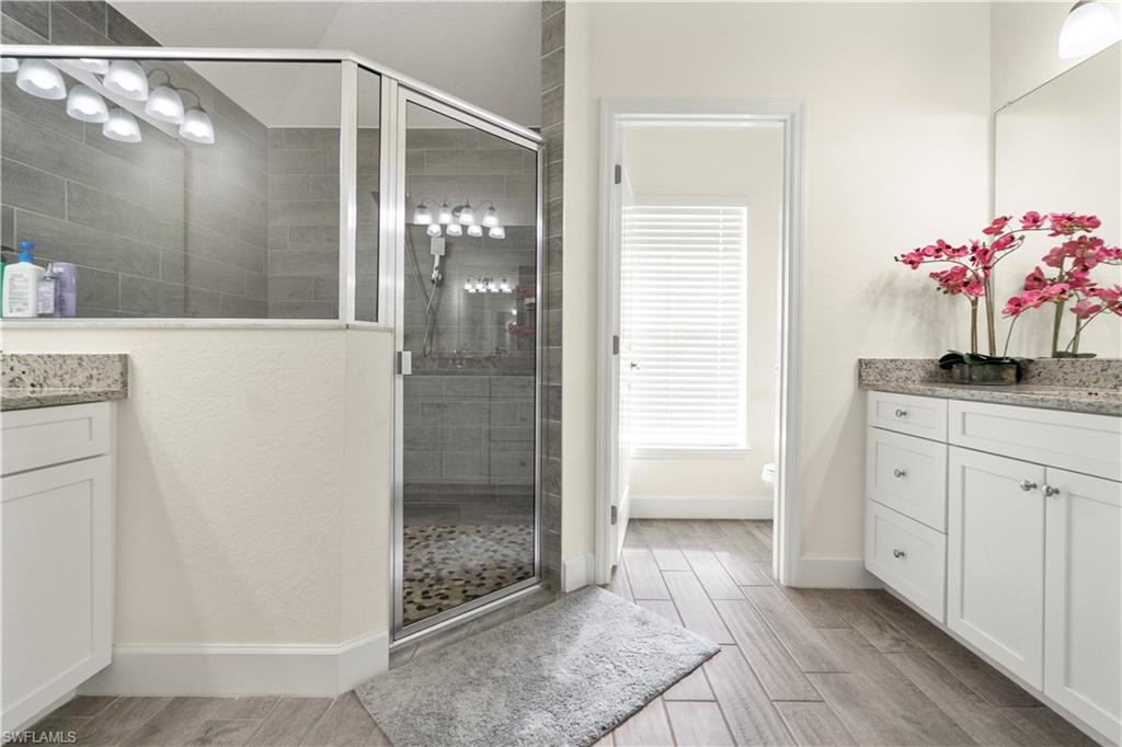 2512 20th Street Southwest Lehigh Acres, FL 33976 - Photo 37 of 48 a bathroom with a granite countertop shower a sink and a mirror