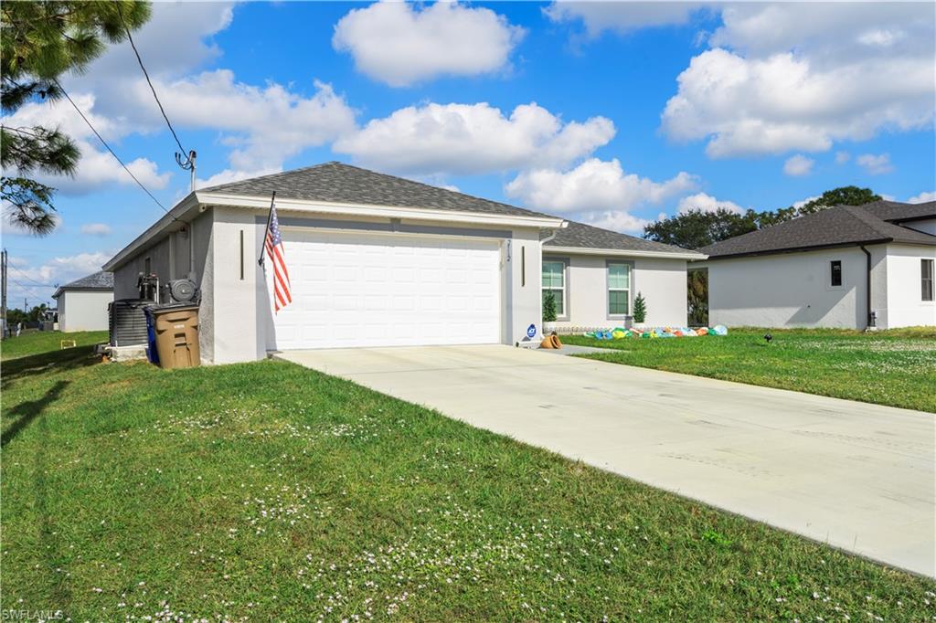 2512 20th Street Southwest Lehigh Acres, FL 33976 - Photo 9 of 48 a front view of a house with a yard and garage