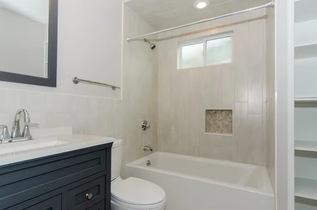 a bathroom with a sink a toilet and shower