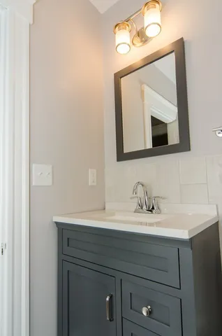 a bathroom with a sink vanity and a mirror