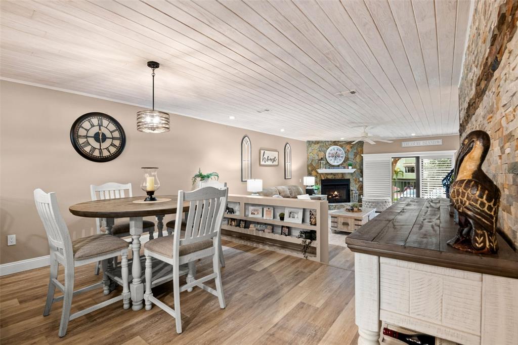 529 Sandy Hook Road Treasure Island, FL 33706 - Photo 12 of 55 a view of a dining room and livingroom with furniture wooden floor a rug a clock and a chandelier