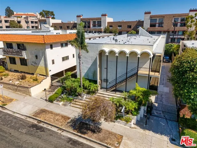 a view of a house with a yard and potted plants