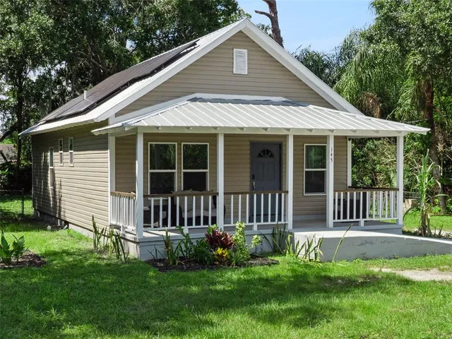 a view of a house with a yard and porch