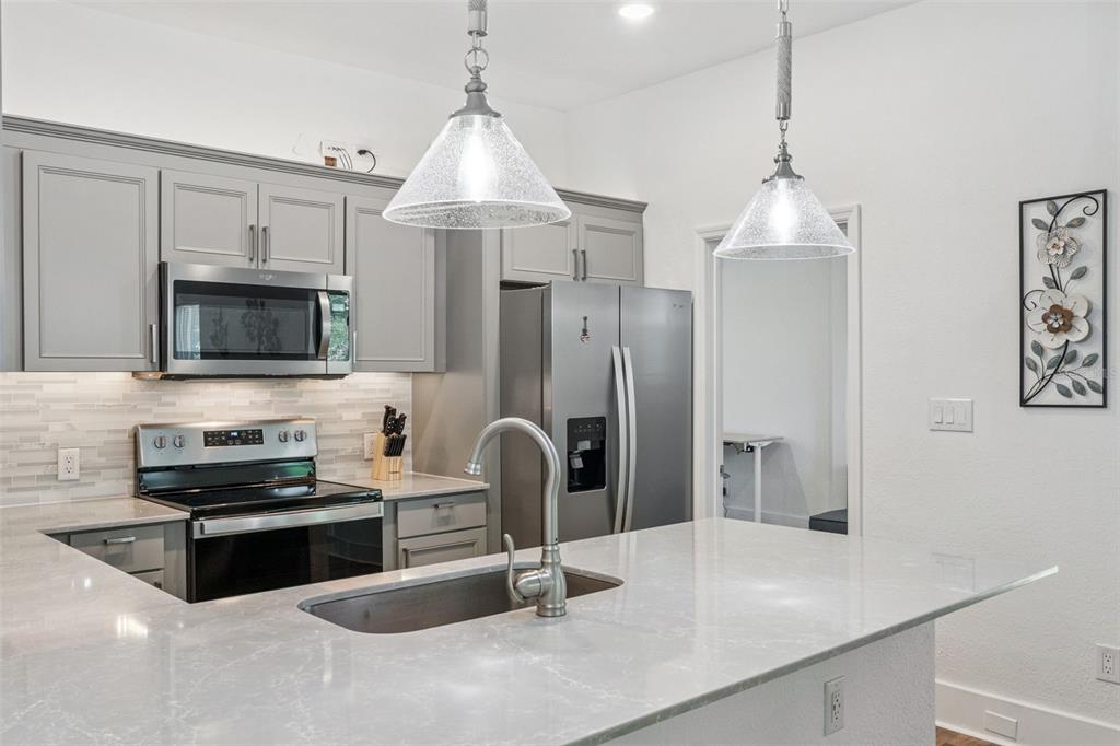 145 Ruth Avenue Cocoa, FL 32922 - Photo 7 of 23 a kitchen with stainless steel appliances granite countertop a sink a stove and a refrigerator