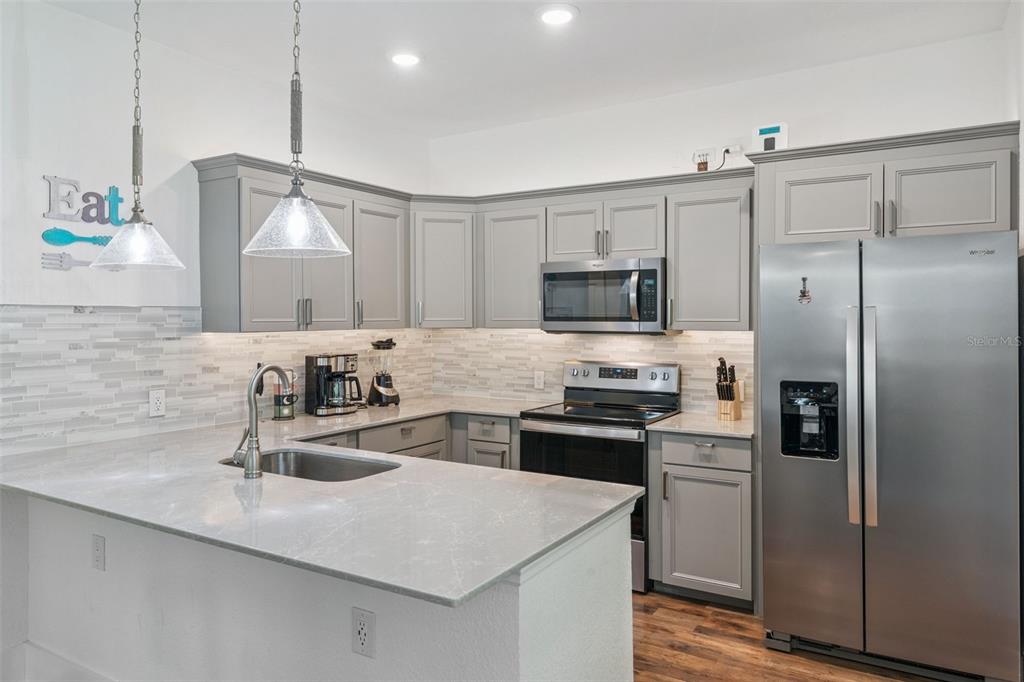 145 Ruth Avenue Cocoa, FL 32922 - Photo 8 of 23 a kitchen with kitchen island a sink appliances and cabinets