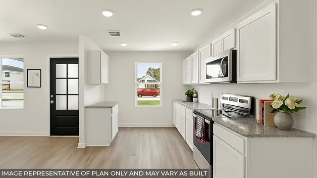 a kitchen with stainless steel appliances white cabinets and wooden floor