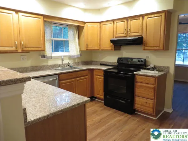 a kitchen with a sink a stove and cabinets