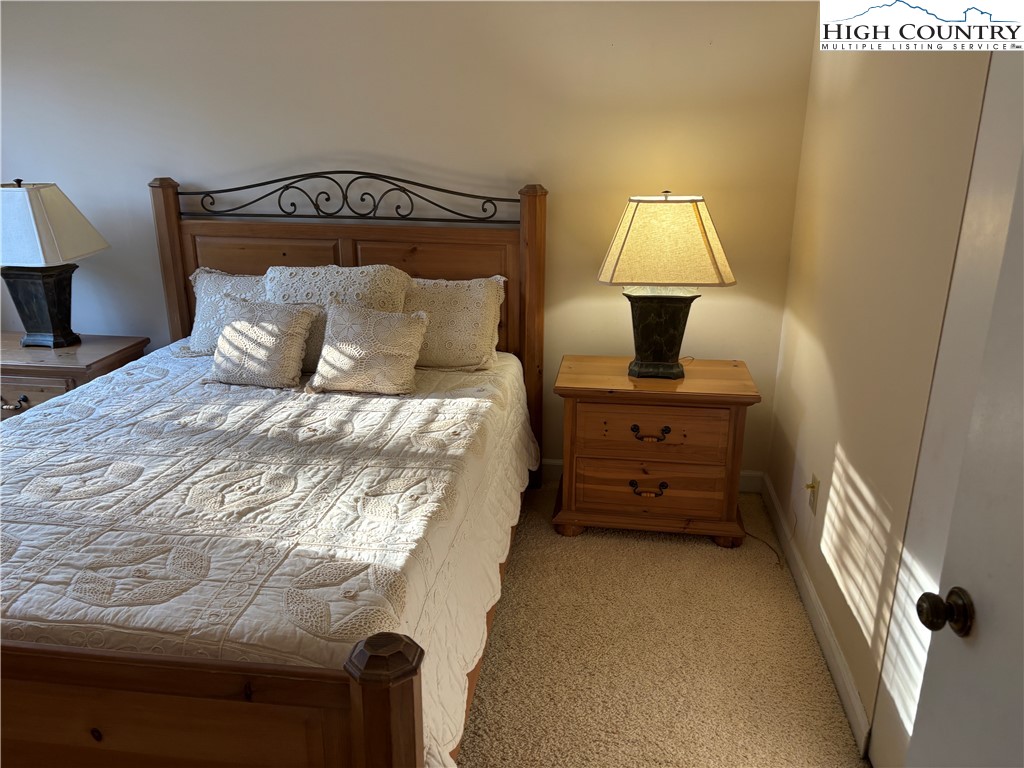 180 Village Drive, Unit 1C4 Boone, NC 28607 - Photo 16 of 23 a bed room with a bed and a night stand