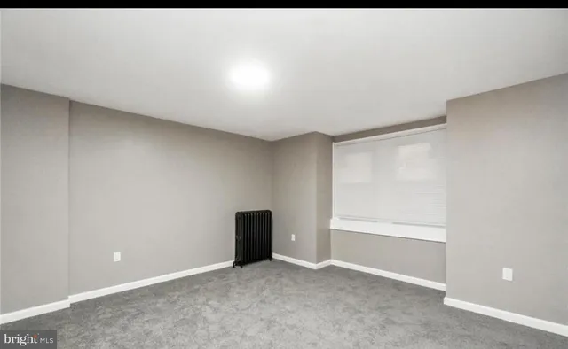 an empty room with closet and windows