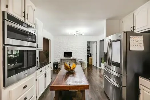 a kitchen with granite countertop a refrigerator stove and sink