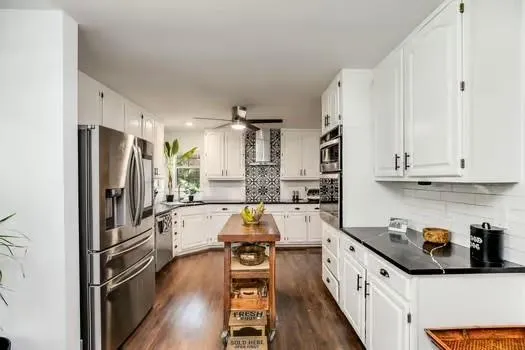 a living room with stainless steel appliances kitchen island granite countertop a stove and a sink