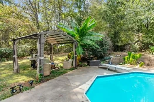 an aerial view of a house with a yard and trees all around