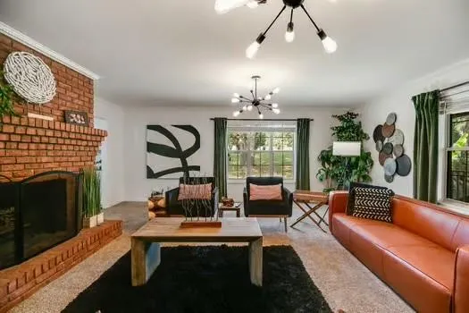 a living room with furniture a fireplace and a chandelier