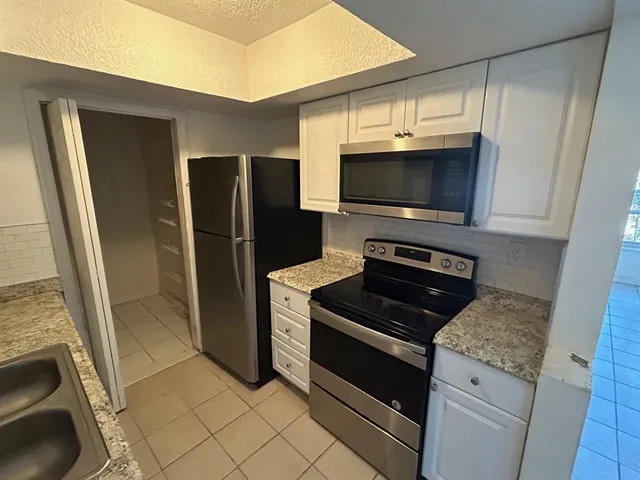 a kitchen with a refrigerator stove and microwave