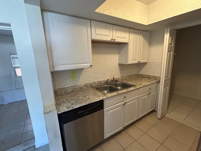 a kitchen with granite countertop a sink stove and cabinets