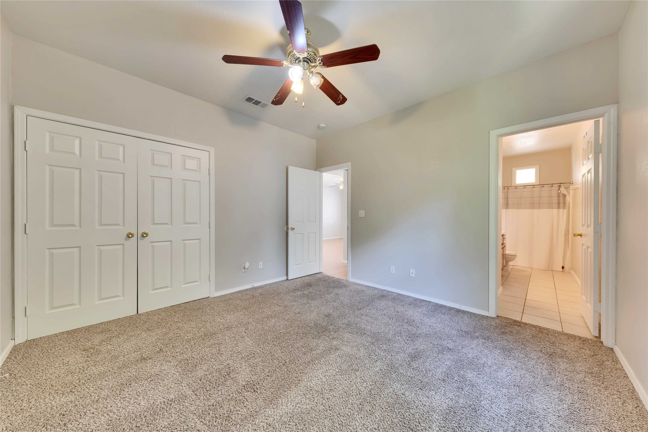 2201 East 18th Street, Unit B Austin, TX 78702 - Photo 11 of 25 A well-lit bedroom with soft carpet, an integrated closet, and easy access to a full bathroom.