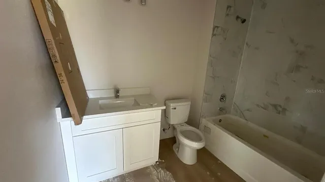 a white toilet sitting next to a bath tub