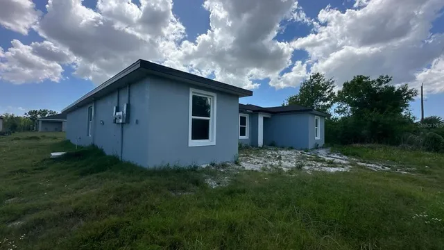 a backyard of a house with lots of green space and wooden fence