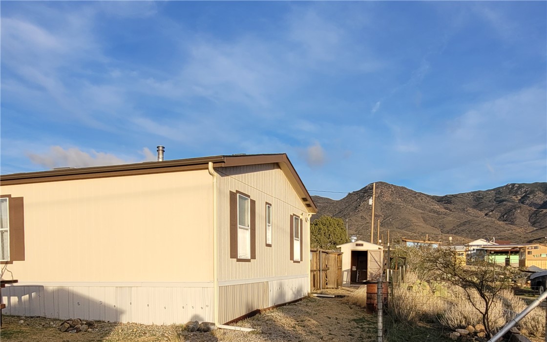 9732 2nd Street Chloride, AZ 86431 - Photo 3 of 28 The property features a neutral-toned exterior with brown shutters and trim