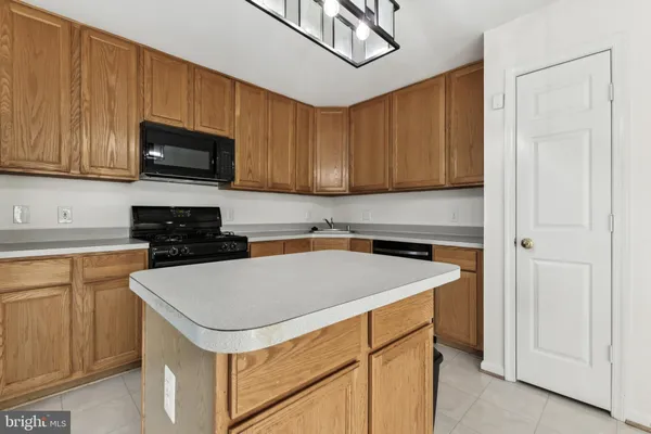 a kitchen with a sink a microwave and cabinets