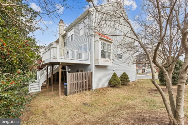 a view of a white house with a large tree