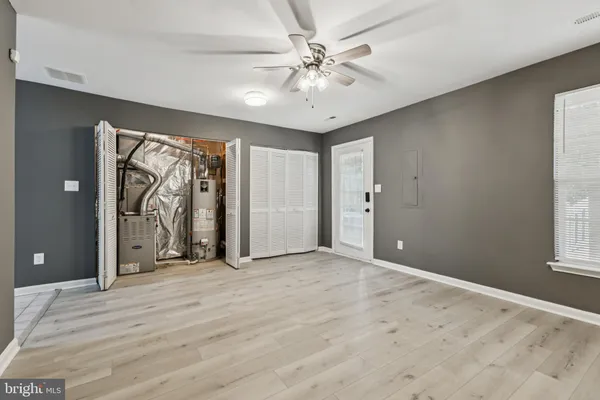a view of a livingroom with a chandelier fan and windows
