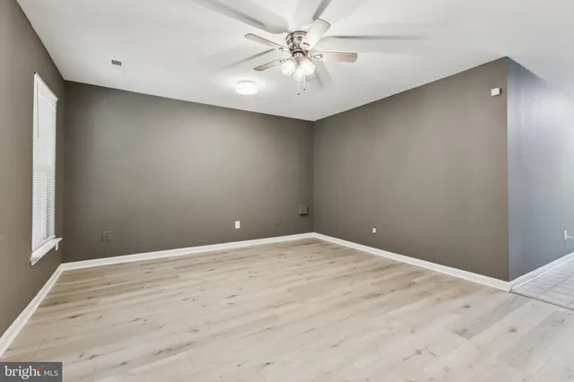 wooden floor in an empty room with a window