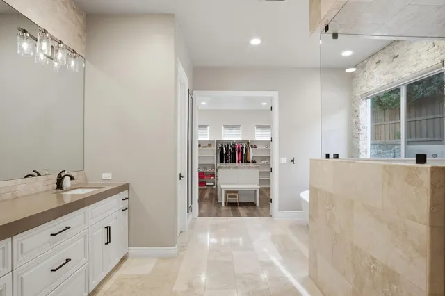 a bed room with a bed a flat screen tv and a chandelier