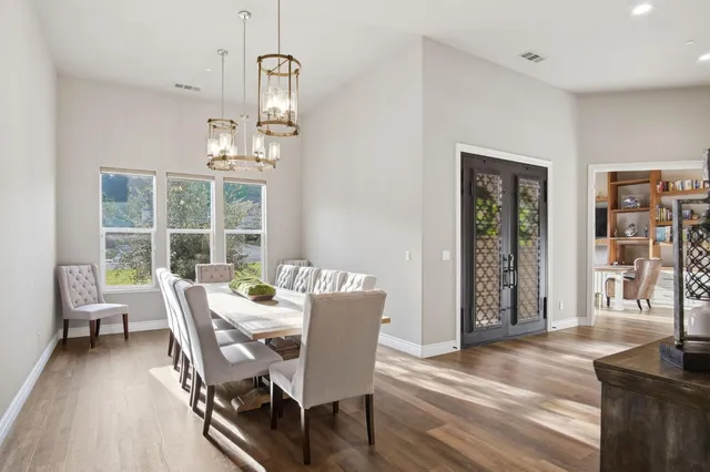a dining room with furniture a chandelier and wooden floor