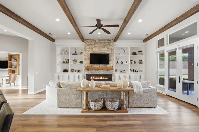 a living room with furniture a flat screen tv and kitchen view